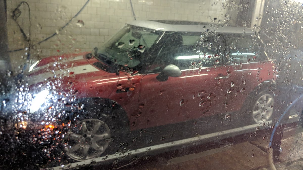 Freshly washed red Mini Cooper parked inside the Avenue Car Wash facility