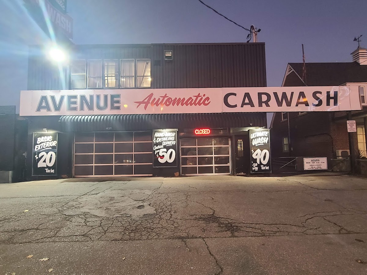 Night view of the Avenue Automatic Car Wash building with illuminated signage and pricing boards